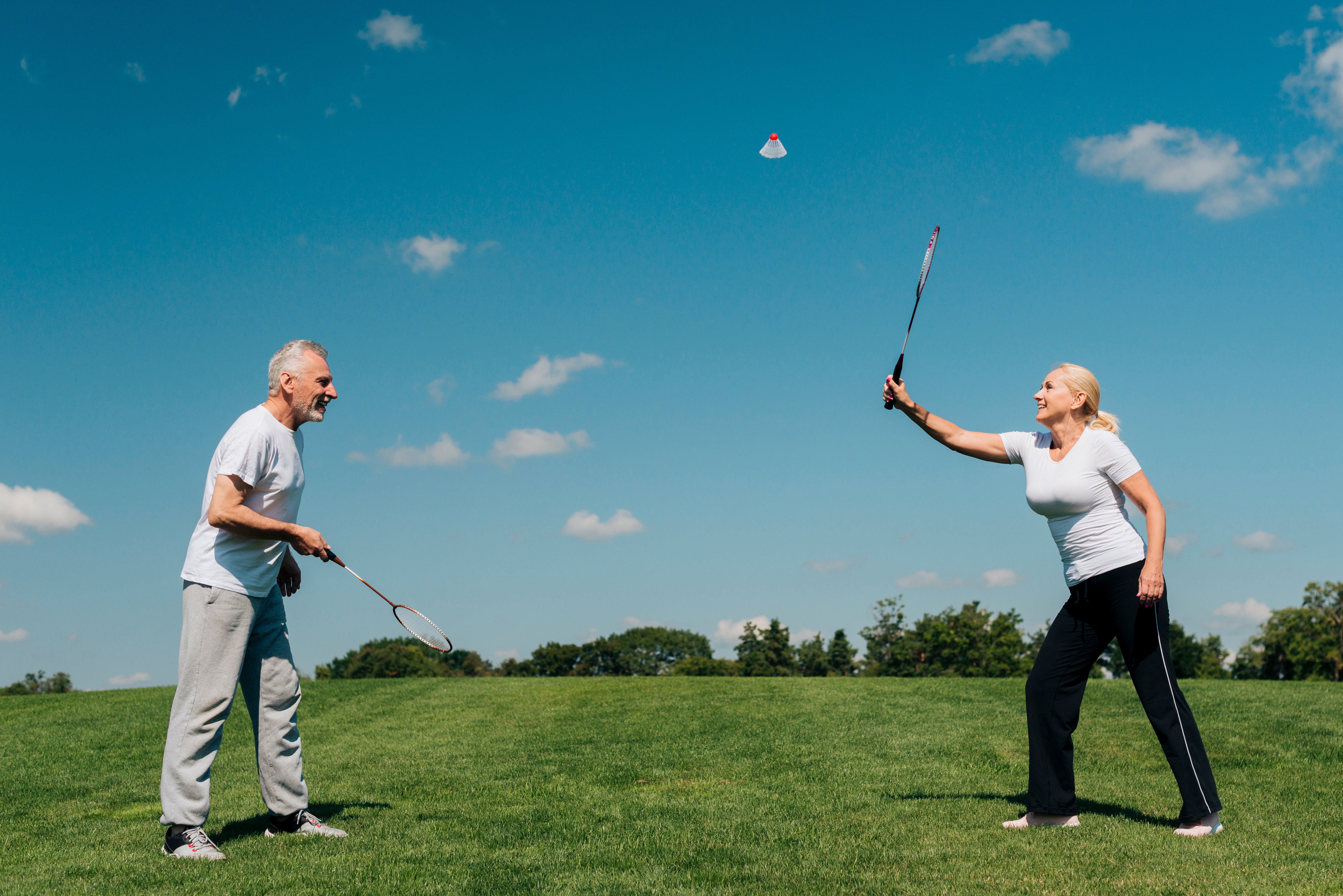 full-shot-couple-playing-tennis-outdoors